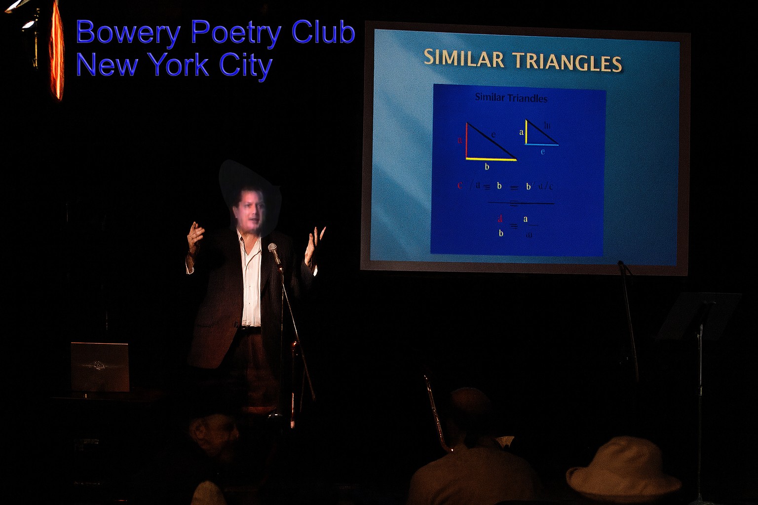 Person giving a presentation at Bowery Poetry Club, New York City, with a slide showing similar triangles on a screen.