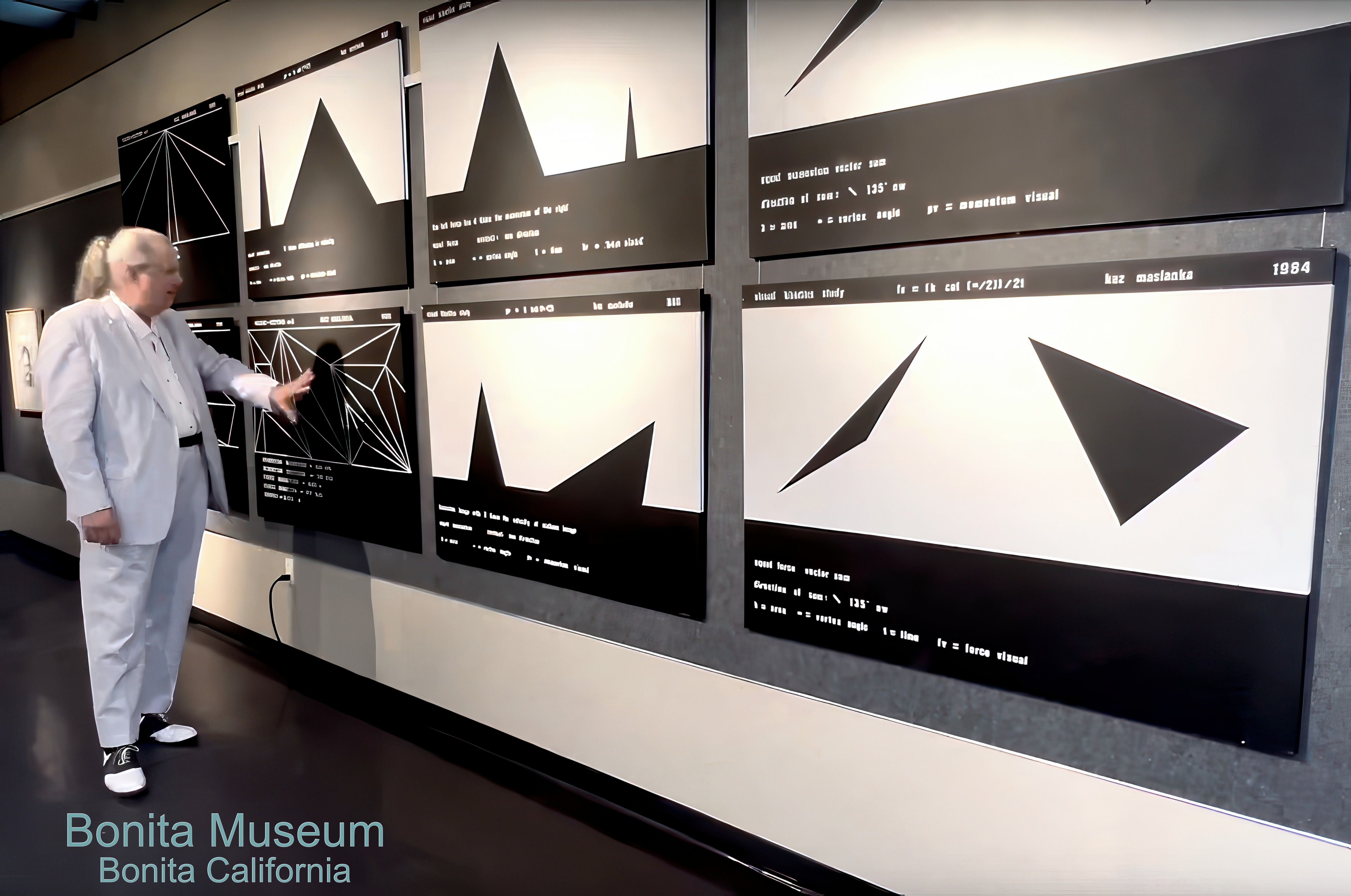 Man in light-colored suit observes black and white abstract graphs on display panels at Bonita Museum, California.