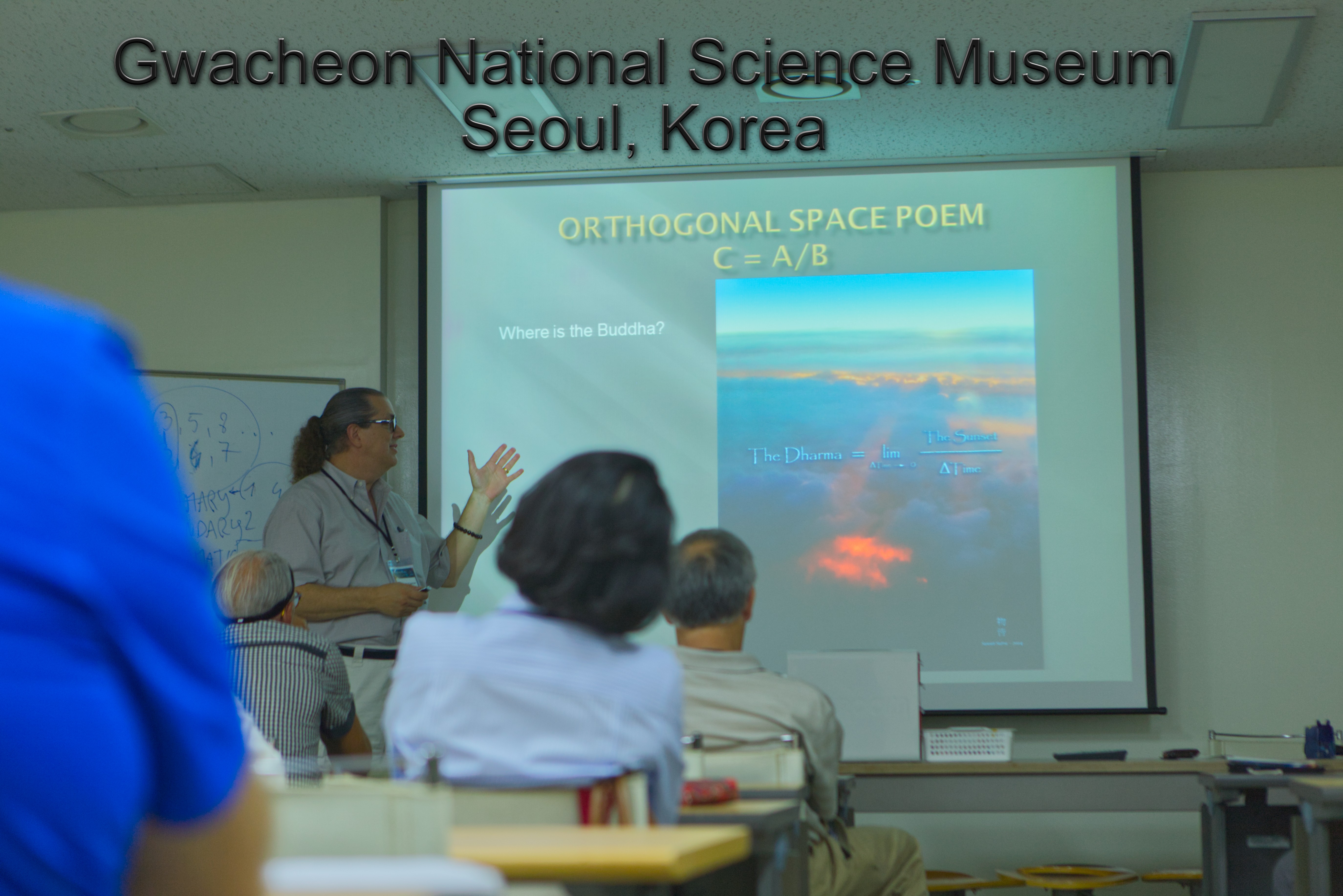 A woman presents a space poem at Gwacheon National Science Museum in Seoul, Korea, with a projected slide showing a sky scene.
