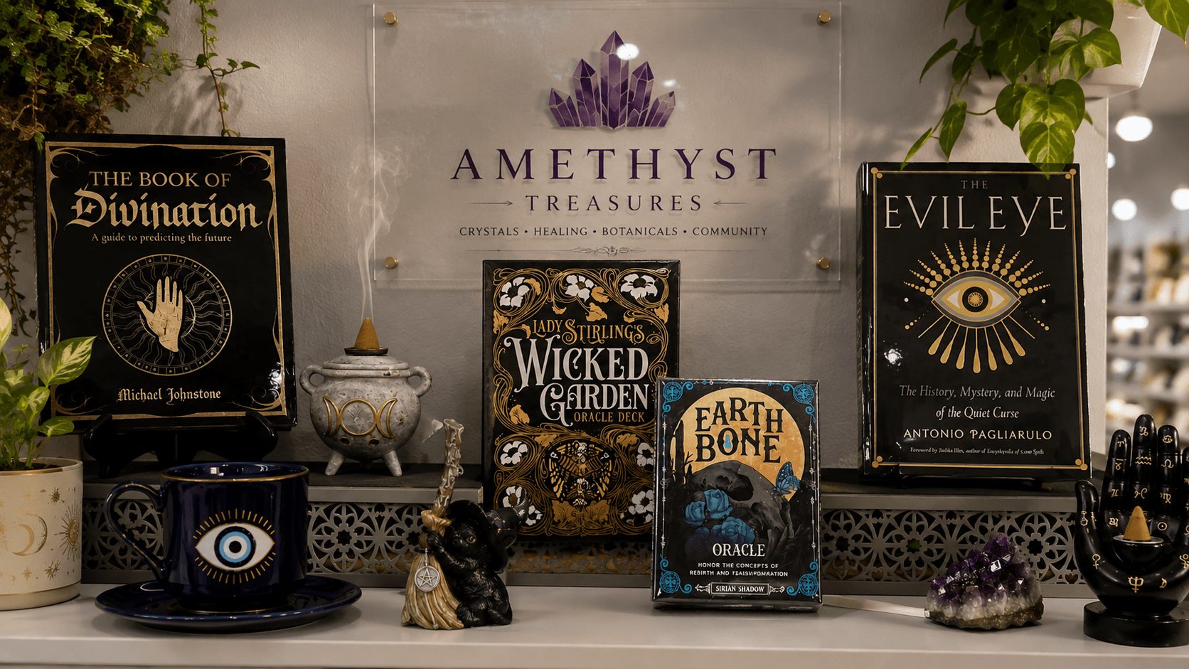 Display of six books and decorative items on a shelf, including titles like 'The Book of Divination' and 'Evil Eye'.