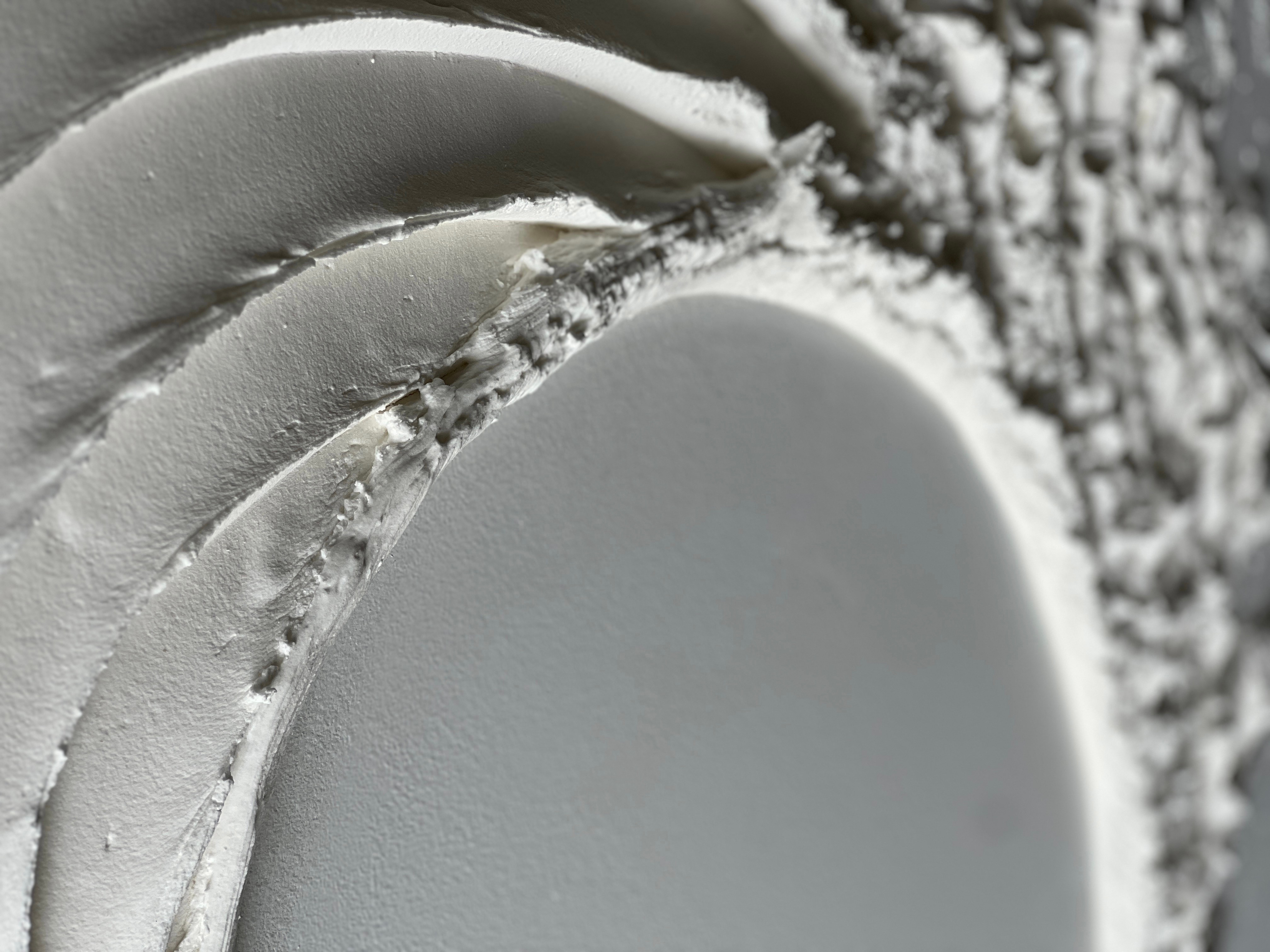 Close-up of snow-covered logs stacked together, with snow on top and sides, and a textured background of snow and ice.