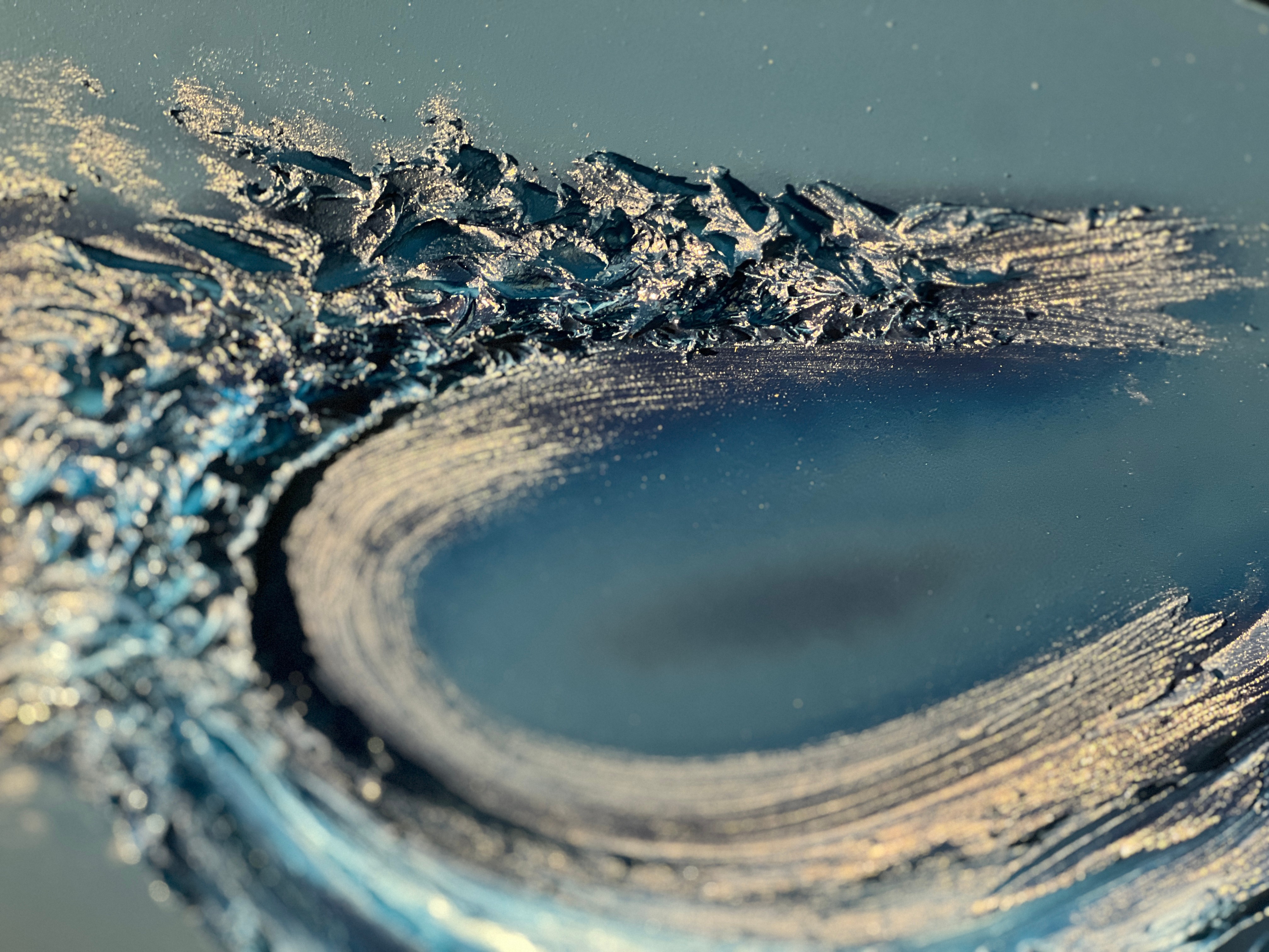 Close-up of a wave curling with foam and water spray, captured from a low angle.