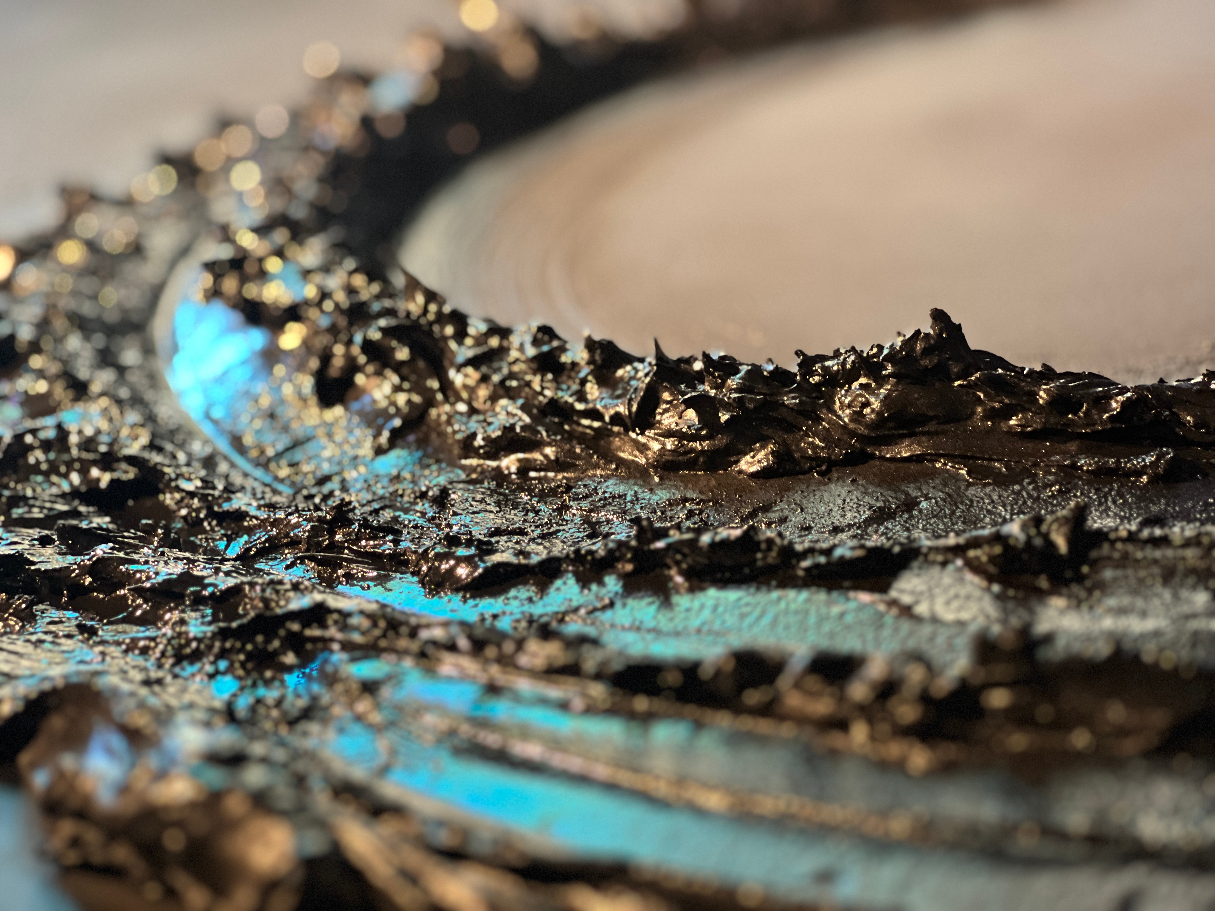Close-up of a textured, metallic, and reflective surface with a curved shape and blue reflections.