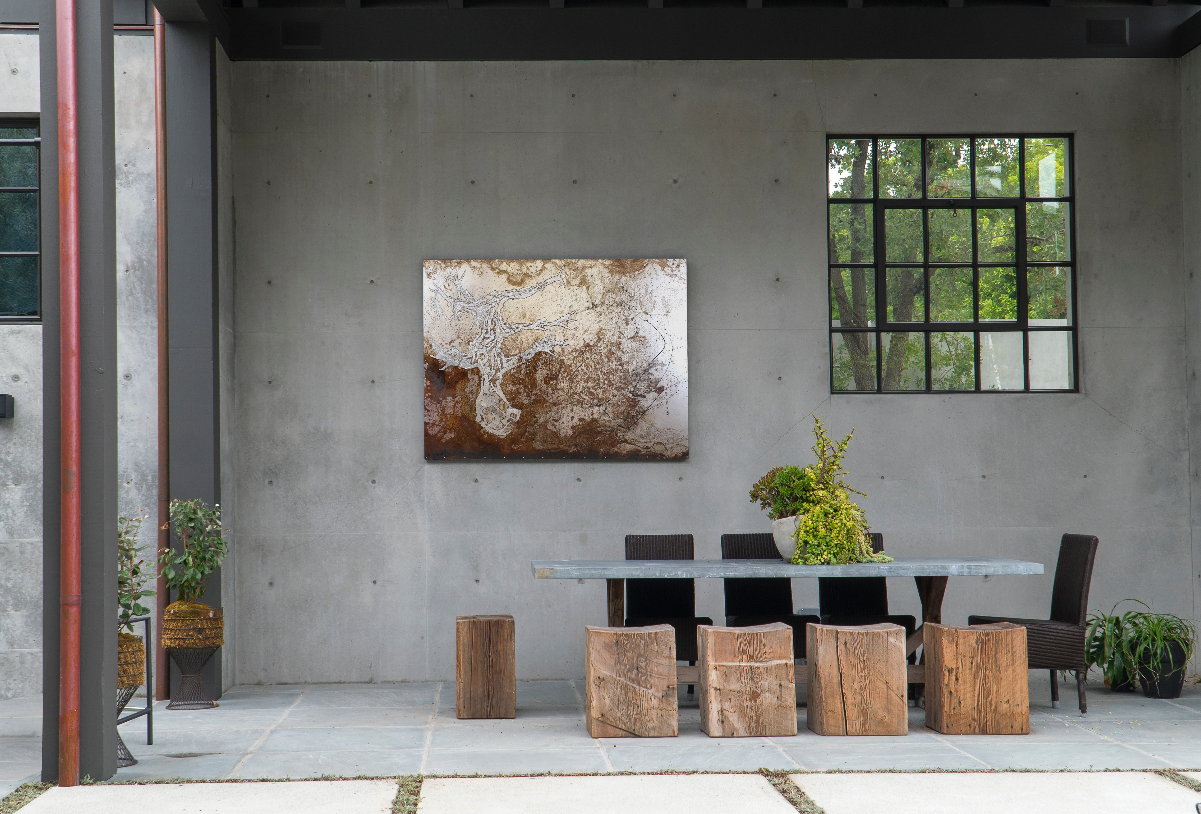 Interior with concrete wall, window, table, chairs, and artwork, in a modern space.