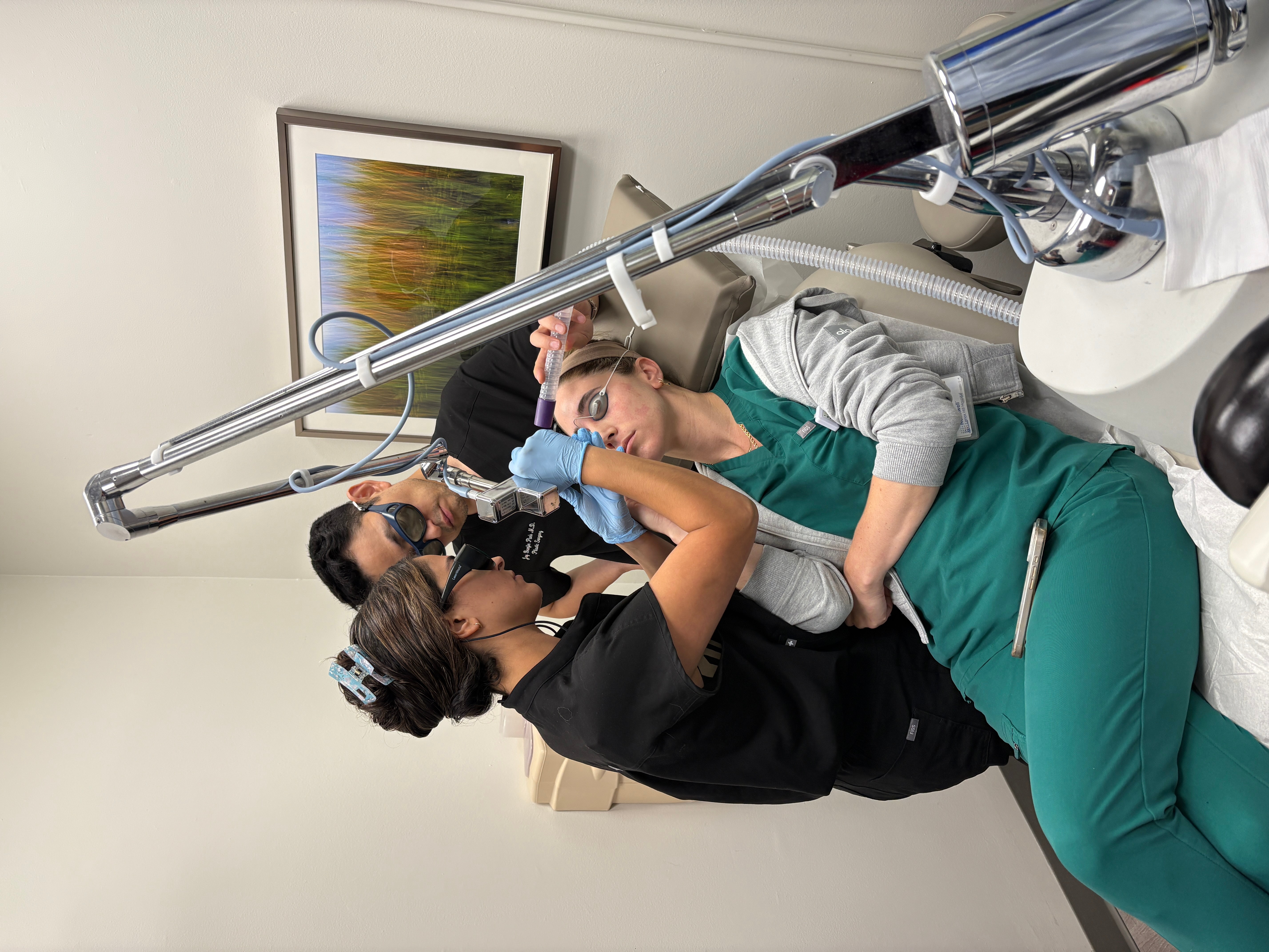 A woman receives a medical procedure from a healthcare professional in a clinical setting.