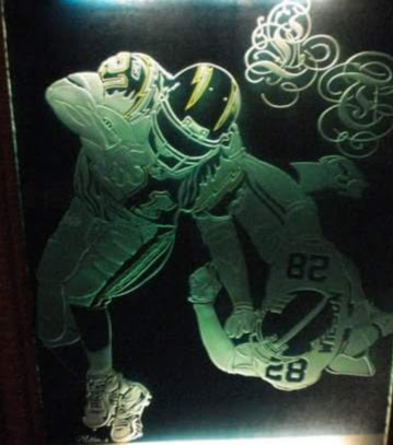 Two football players in helmets and uniforms, one kneeling and the other standing, with a football on the ground and decorative swirls above.