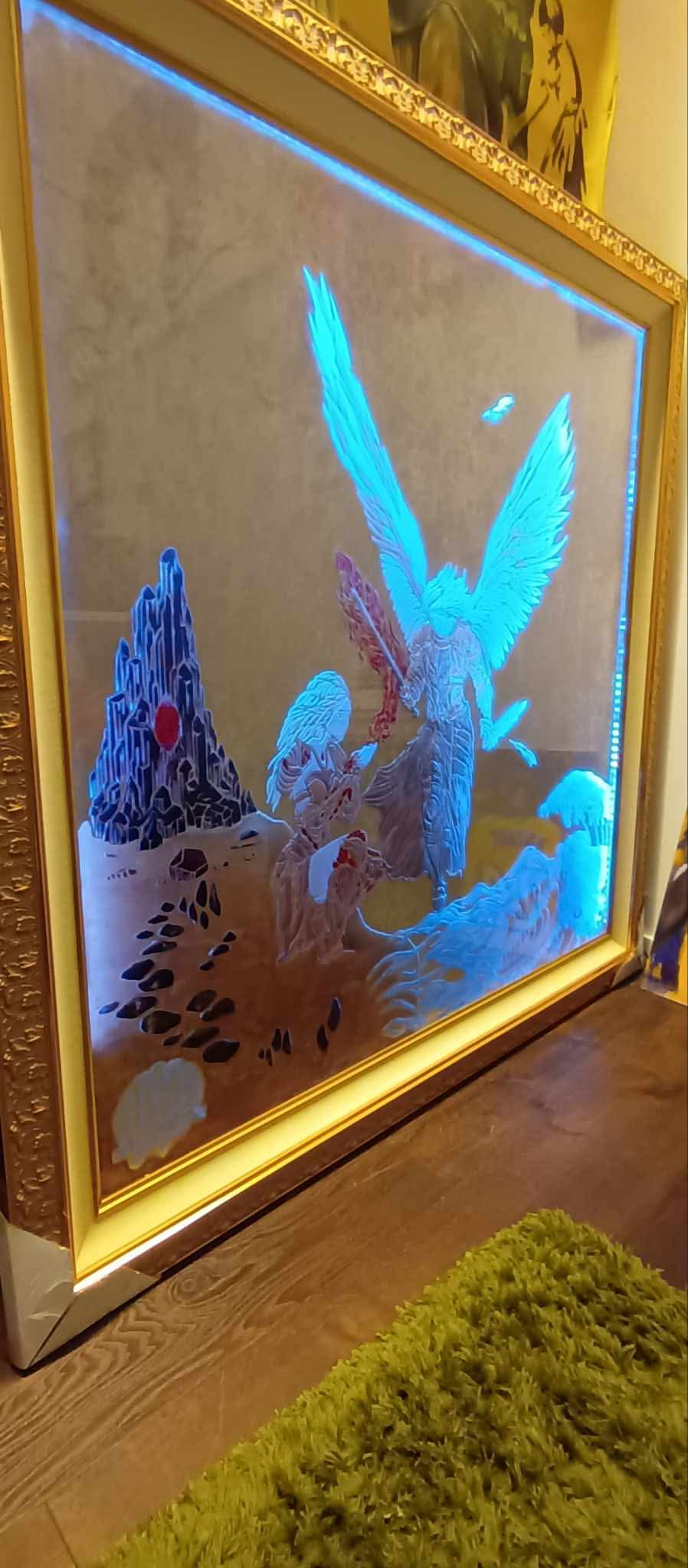 Framed illuminated artwork featuring a bird with wings spread, surrounded by abstract shapes and patterns, on a wall.
