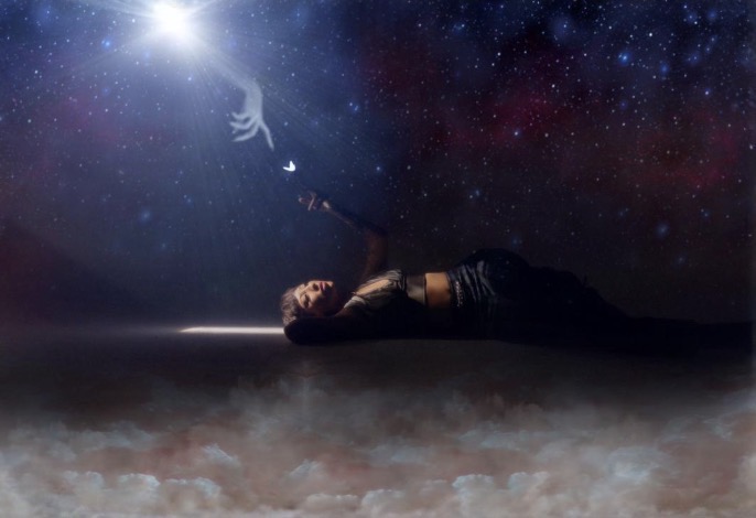 Person lying on ground reaching toward the starry sky with a bright light, clouds below, and a cosmic background.